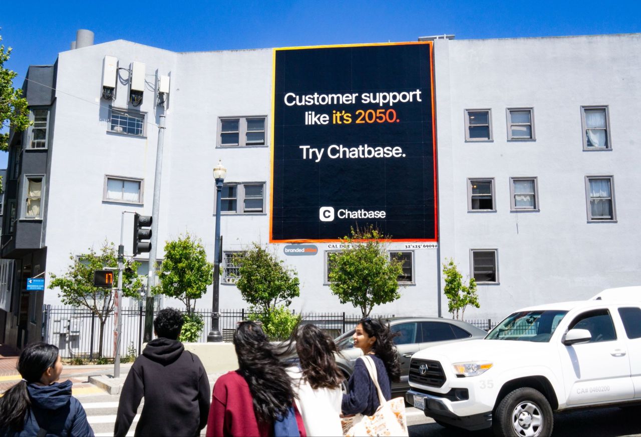 Chatbase outdoor billboard advertisement on building wall reading Customer support like its 2050 Try Chatbase with pedestrians walking on street below